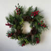 An artificial wreath that looks natural. Pine with pine cones and red