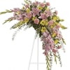Soft, soothing pink lilies and yellow daisies are crafted into a crescent