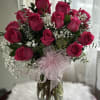24 hot pink roses, baby breath and greens foliage in a clear