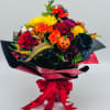 

A fall-colored bouquet housed in a sleek vase, wrapped in waterproof paper