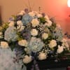 This is a beautiful draping large casket spray of blue hydrangeas, white