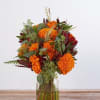 A glass vase filled with beautiful Marigolds and accenting flowers, 
