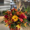 Fall color flowers with a cute glass pumpkin container