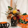 A seasonal mix of flowers and foliage in warm fall colors and