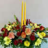 Thanksgiving centerpiece featuring an assortment of fall flowers arranged in a floral