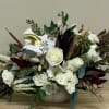 White roses, burgundy flowers, and mixed greens in a white pumpkin
