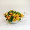 A modern, medium compact arrangement with tones of amber. Comprised of ranunculus