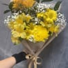 A radiant bouquet of yellow blooms and delicate white baby breath 