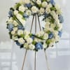 
The Blue Serenity Wreath is a graceful tribute crafted with soft ivory