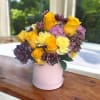 Lavender Blooms is a graceful and soothing floral arrangement that captures the