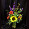 A bright mixed medium size vase arrangement using flowers such as Sunflowers