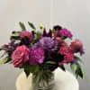 Beautiful arrangement created with rich jewel tones. Consists of roses, dahlias, lisianthus