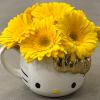 This design includes a hello kitty coffee cup with 7 Gerbera Daisy