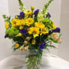 Yellow daisy, green button, yellow alstromeria, yellow snap dragons

and purple statice in