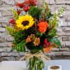 This cheerful fall arrangement bursts with the vibrant hues of the season