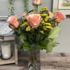 Six Shimmer  roses arranged in a clear glass vase with greenery