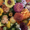 Floral arrangement in seasonal fall hues - yellows, orange, peach, magenta, fuchsia