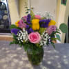 A compact glass vase filled with 9 short assorted color roses, 