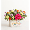 In a special container.
Hot pink rose, orange spray rose, purple buttons, and