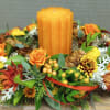A table wreath wrapping a large candle with local fauna and thoughtful