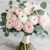 This bridal bouguet features only white and pastel pink ranunculus.