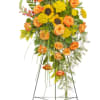 This beautiful standing spray includes sunflowers, roses with accent flowers and premium