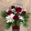 Send holiday tidings with this festive arrangement.  Arrangement includes red roses