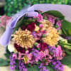 A modern mix of purples, cream and pink florals in a hand