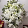 An elegant standing spray crafted in serene shades of white, symbolizing peace