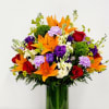 A striking fall arrangement featuring vibrant orange lilies, rich purple blooms, red