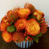 in a very nice vase with a orange roses and pink cushions