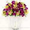 A luxurious fall arrangement of green and deep purple orchids, gracefully floating