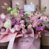 An opulent garden of blush roses, spray roses, and lilac stock blooms