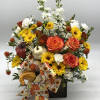 A beautiful fall mix of flowers with fall bow and pumpkin accents