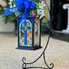 Battery operated cross lantern with a metal stand. The silk flowers will