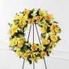 A striking floral tribute of golden blossoms in a classic funeral wreath