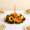 All-around arrangement with autumn-colored roses, sunflowers, red daisy poms, orange Asiatic lilies;