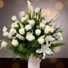 A graceful display of pure white roses, lilies, and calla lilies &mdash;