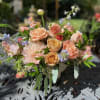 a selection of peach toned blooms that includes roses, stock, and renunculus