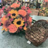 A bountiful of fresh Autumn blooms fill this wicker cornucopia.  
Flower
