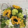 Cute arrangement of sunflowers and green blooms arranged in a 5x5 cylinder