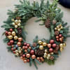 Mixed holiday greens, pine cones, millimeter balls.