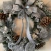 Faux Christmas wreath adorned with silver balls and  ribbons and pine