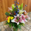 A whimsical and colorful mix of fresh flowers including lilies, delphinium, chrysanthemum