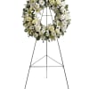 A standing wreath created from fresh white flowers such as roses, Asiatic