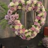 A floral heart wreath with a combination of flowers:  roses, carnations