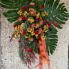 This awsome tribute spray features large Monastera Leaves, Roses, Mums and Fall