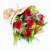 Christmas bouquet made of red roses, hydrangeas, tulips, cedar, and noble fir.