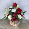A classic holiday arrangement featuring red roses, beautiful white asiatic lilies, fresh