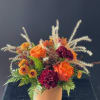 A fall inspired arrangement with roses, mini carnations, cushion sprays, solidago and